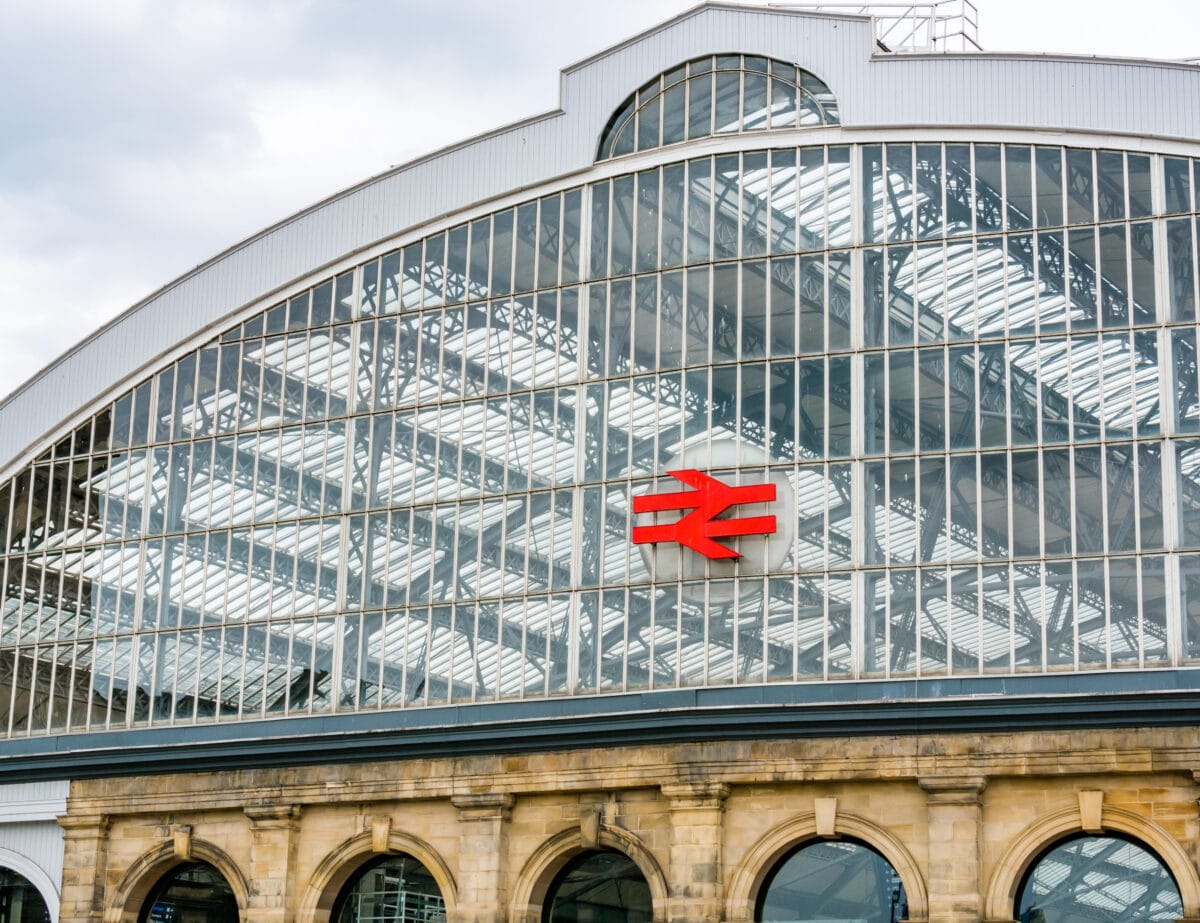 Curved glass roof of Liverpool Lime Street mainline railway station with the Double Arrow symbol, Liverpool, England, UK