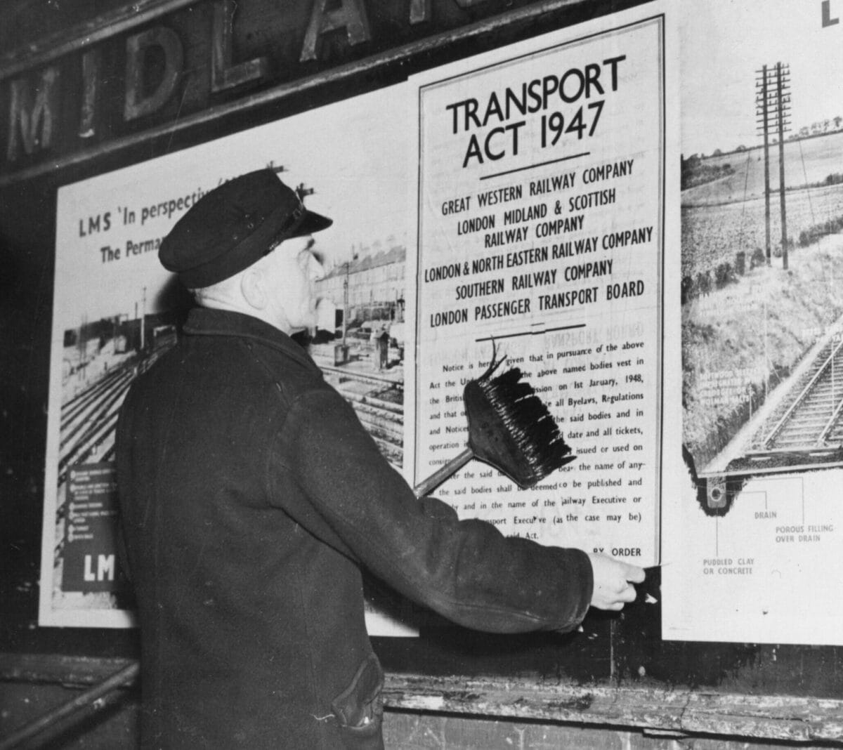 A person putting up a poster with the words Transport Act 1947 on