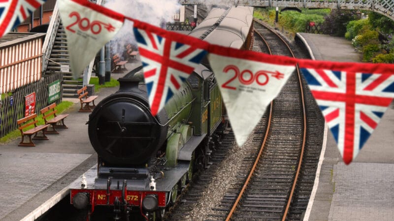 Banner of British Union Jack flag hanging in a train station alongside a steam train