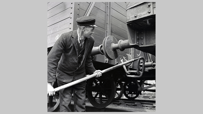A railway guard shunting, connecting, rolling stock by using special equipment known as a shunter's pole or draft gear