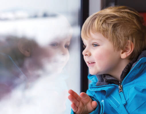 Young boy looking out of train window