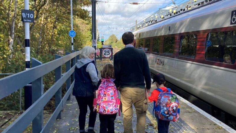 Grandparents day out with grandchildren on a station platform about to board a train