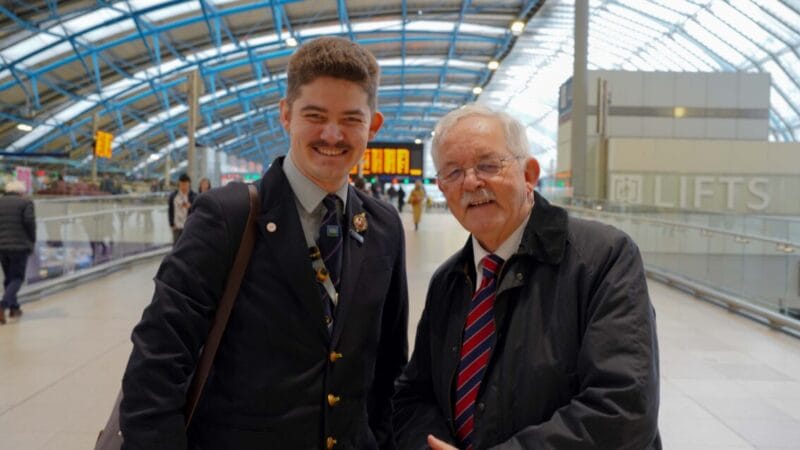 A photo of Mike and Andrew Lamport, smiling, at Waterloo Station