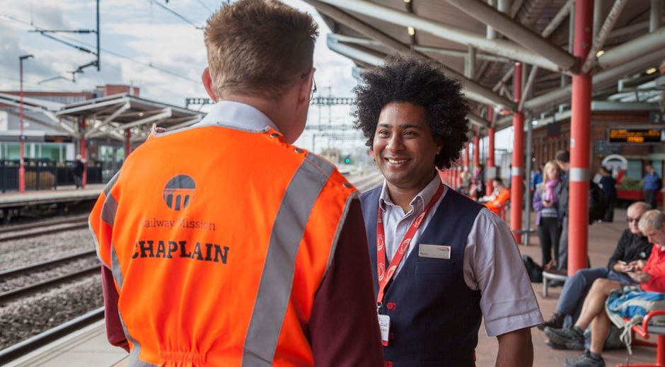 A photo of a Railway Mission chaplain talking to a member of rail staff on a platform