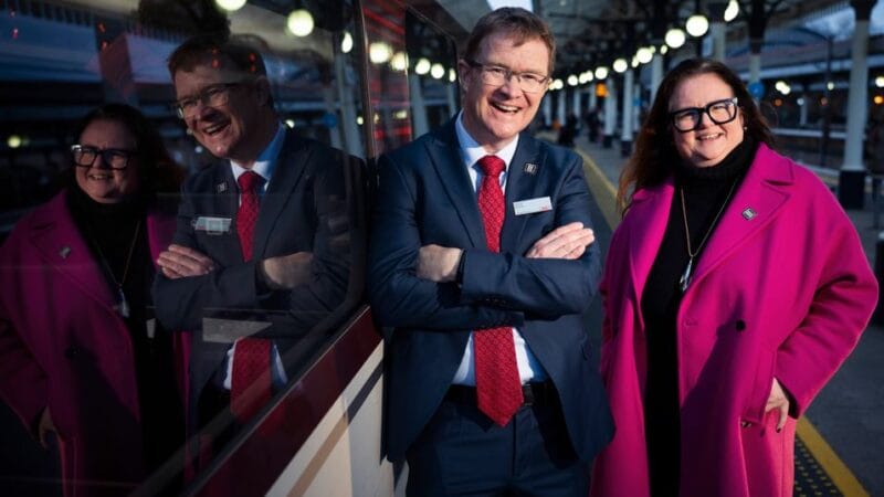 A photo of David Horne and Niccy Hallifax standing next to a train