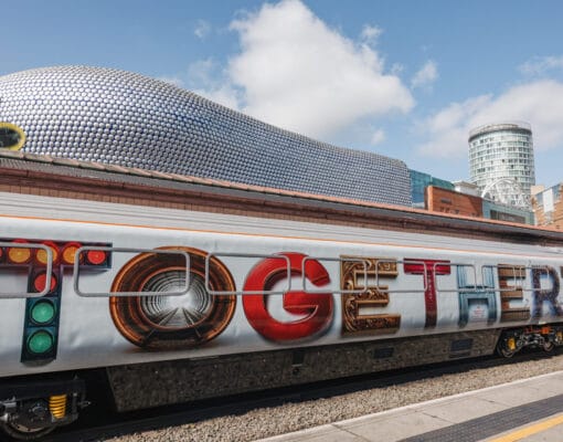 A white train carriage with the word 'Together' on the exterior