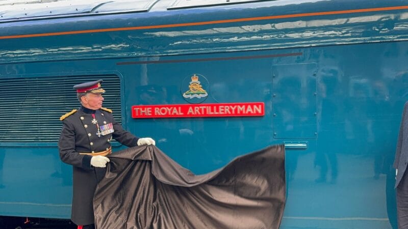 Photo: South Western Railway Uniformed Army officer unveiling a name plate on the side of a blue locomotive